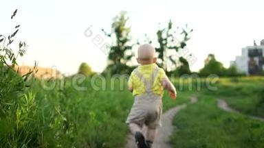 单身婴儿独自走在农村的路上，单身孩子与后退准备新的冒险。 孩子摔倒了